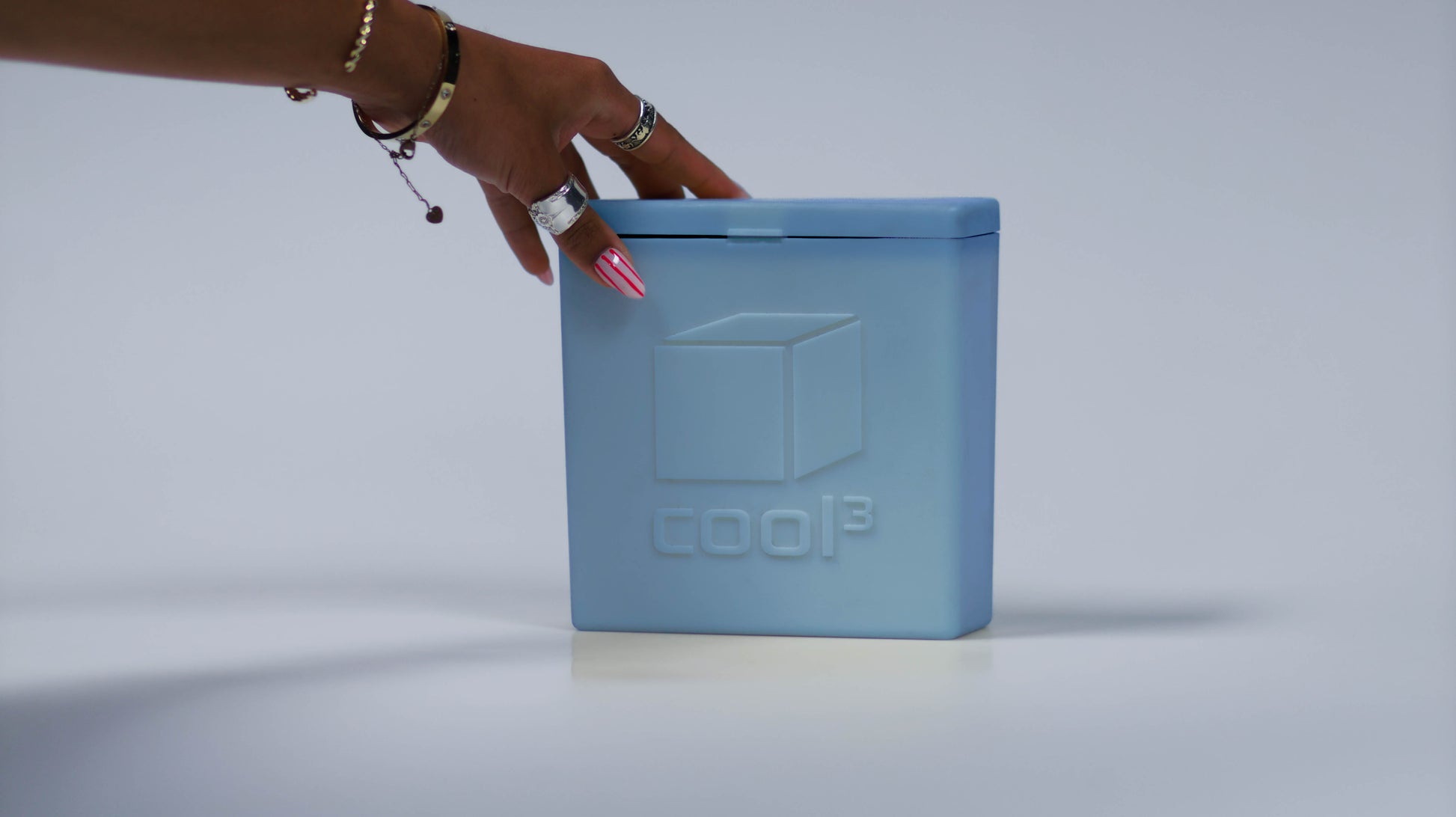 Hand grabbing top of Cool 3 ice pack.